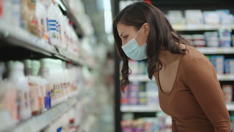 Portrait-of-a-girl-near-refrigerators-in-a-supermarket-in-a-protective-mask
